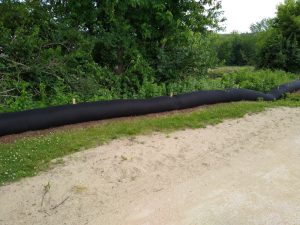 black wood chip barrier along a creekside path